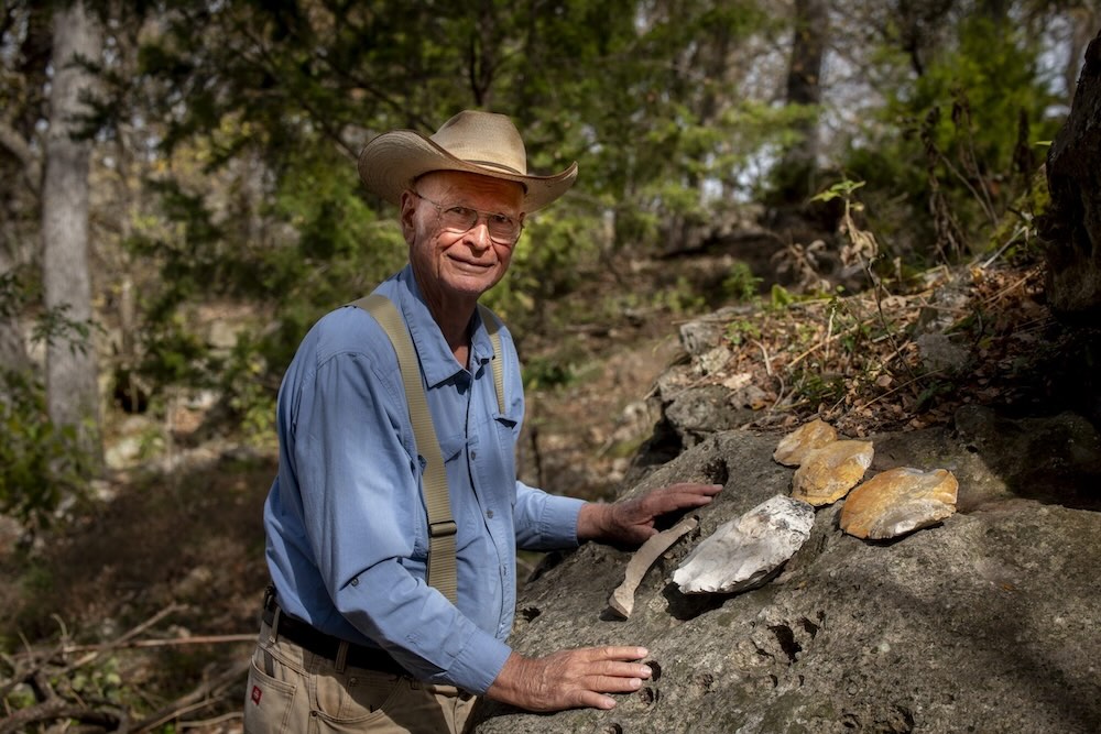 Photo of Mike Collins examining stone artifacts